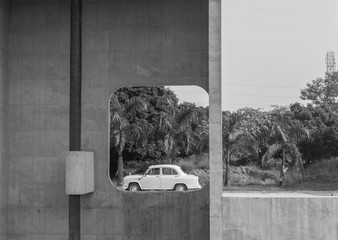 Exact moment when a car passed behind the Open Hand Monument portrait hole At Capitol complex, Chandigarh, India