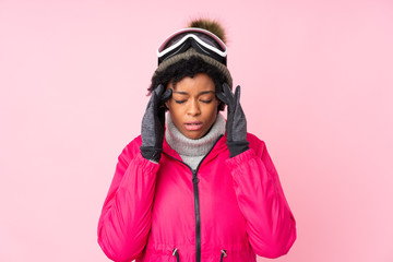 African american skier woman with snowboarding glasses over isolated pink background unhappy and...