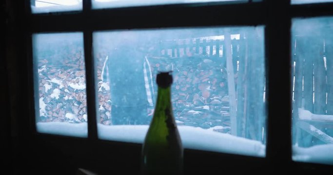 A man lumberjack goes to chop wood. view through a window in a barn.
