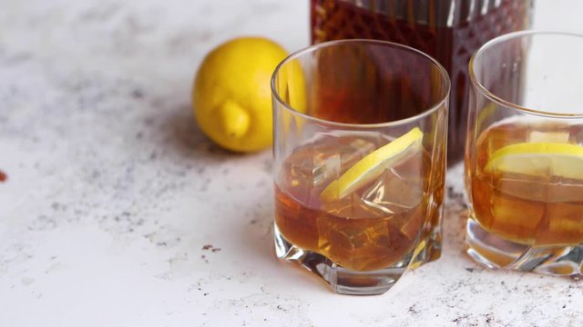 Whiskey sour drink with lemon in glass on stone rustical background