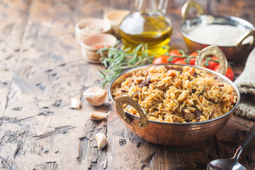 Lamb pilaf in a bowl on wooden rustic background with copy space