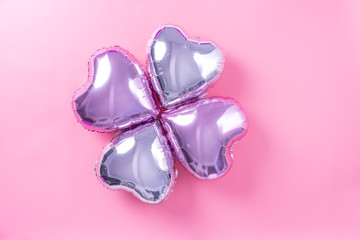 Valentine's Day minimal design concept - Beautiful real heart shape foil balloon isolated on pale pink background, top view, flat lay, overhead above photography.