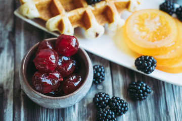 Petit déjeuner sain avec lait gaufre mûres du jardin et fruits confits	