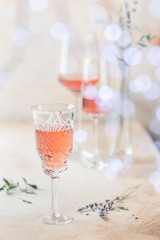 Different shapes of glasses of rose wine on light background.