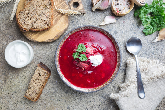 Beetroot soup: Traditional Ukrainian or Russian borscht with sour cream in a bowl, top view