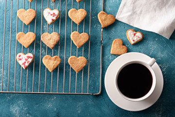 homemade heart-shaped iced cookies with cup of red tea