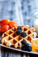 Petit déjeuner sain avec lait gaufre mûres du jardin et fruits confits	