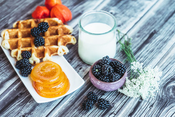 Petit déjeuner sain avec lait gaufre mûres du jardin et fruits confits	