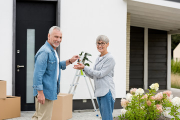 mature man giving keys of new house to smiling woman