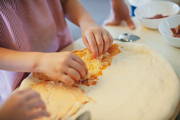 a child learns to cook pizza