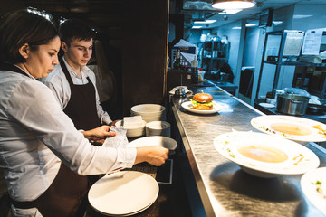 Waiters pick up ready meals in a restaurant at the counter for dispensing dishes