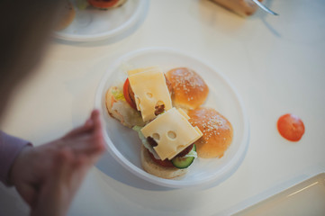 a child prepares mini burgers at a cooking class