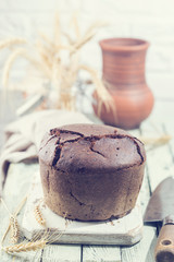 Fresh homemade traditional round rye bread on rustic wooden background