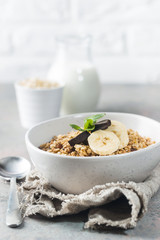 Healthy breakfast bowl. Granola with chocolate and banana on gray table. The concept of healthy nutrition and diet.
