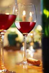 Rotweingläser und Flasche im Kerzenlicht