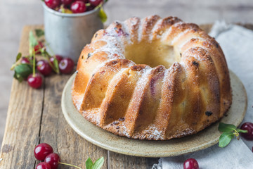 Fresh homemade bundt cake with cherry on wooden table