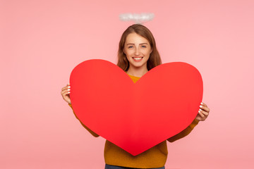 Angel on Valentine's day. Portrait of lovely ginger girl with halo over head smiling at camera and...