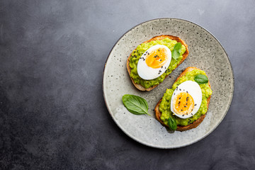 Healthy breakfast, toast with avocado and egg, top view, copy space. Vegetarian food concept