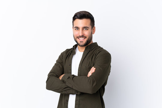 Young handsome man with beard over isolated white background with arms crossed and looking forward