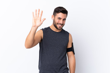 Fototapeta premium Young sport handsome man with beard over isolated white background saluting with hand with happy expression