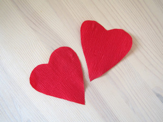 Obraz premium Two paper hearts on the white wooden background
