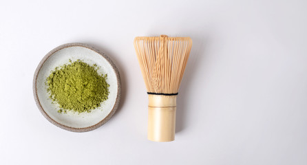 White ceramic spoon with tea of a match on a light gray background