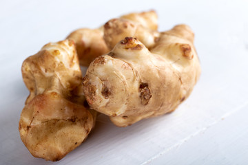 Fresh Jerusalem artichokes on the old wooden table.
