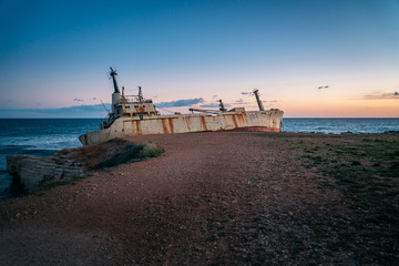 An old ship stranded stands on the seashore.