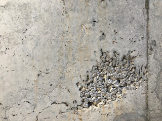 Concrete surface with caverns and exposed gravel stones