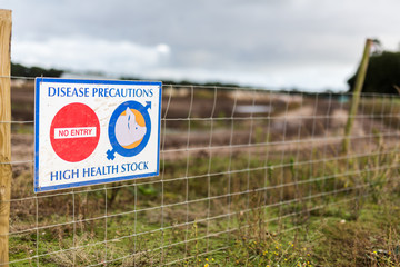 A disease prevention area sign out side of a pig farm to keep unauthorized people entering and spreading a disease amongst livestock