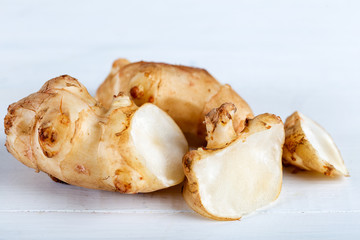 Fresh Jerusalem artichokes on the old wooden table.
