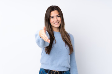 Teenager girl over isolated white background shaking hands for closing a good deal