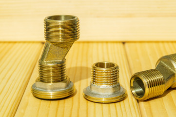 View plumbing tools brass pipe connectors on wooden board close up