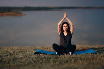 Fototapeta na wymiar Pregnant Woman in Lotus Pose Doing Prenatal Yoga 
