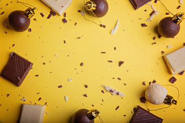 Christmas New Year balls made of chocolate and pieces of white and dark chocolate on a bright...