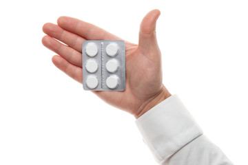 Man hand with pills blister isolated on white background. White shirt, business style. Medicament and food supplement for health care. Pharmaceutical industry. Pharmacy.