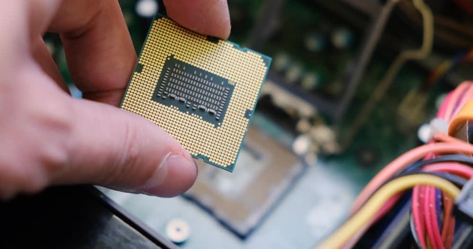 Examining a computer CPU up close above a motherboard. PC custom build.