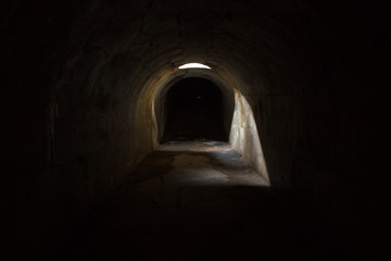 A gloomy dark underground corridor, sealed through a hole in the ceiling at Fort Pospelova on the Russian island in Vladivostok.