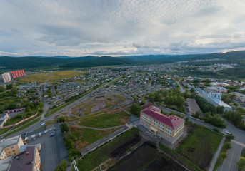Satka city. School, private houses and mountains. Chelyabinsk region, Russia. Aerial, summer, evening