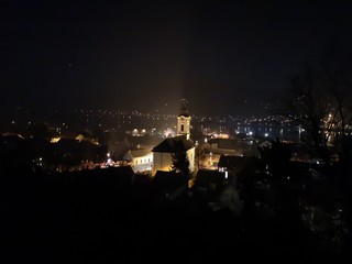 Fototapeta na wymiar Night view of the city of Visegrad from the hilltop, with the light up church in the middle