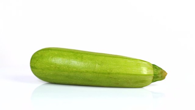 Fresh zucchini rotating on white turntable