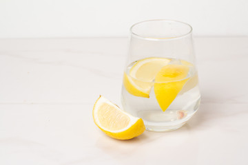 glass of water and orange on wooden background