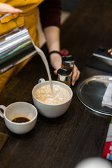 cappuccino with milk in a white mug on a brown background