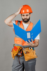 Builder or worker in a protective helmet with drawings in his hands. Isolated on grey background