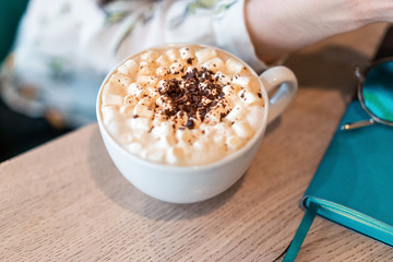 cappuccino with milk in a white mug on a brown background