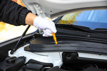 Fototapeta na wymiar Hand pulling a car's dipstick. Checking engine oil step by step.