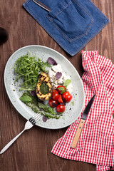 Grilled avocado with red cherry tomatoes basil pesto sauce mozzarella cheese with green arugula fresh leaves on a white plate 