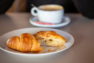 Desayunando un croissant con café con leche