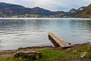 moody weather time poor pier wood deck lake waterfront with beautiful peaceful landscape environment village on opposite site of reservoir and mountain background