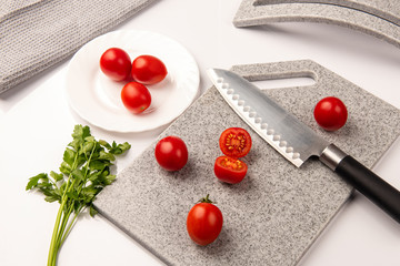 Fresh tomatoes on a cutting kitchen board made of artificial stone
